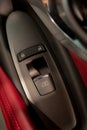 Window controlling button on the door console, black leather red lether, close-up. ÃÂ¡ar interior details Royalty Free Stock Photo