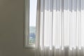 Window with curled white curtain