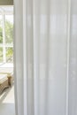 Window with curled white curtain