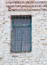 Window with Dirty Glass and Worn Turquoise Trim in a White Stone Wall Royalty Free Stock Photo