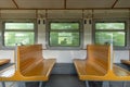 Window in empty vintage salon of an old urban train with empty yellow wooden seats. Empty interior of a passenger train. Royalty Free Stock Photo