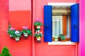 Window with flowers on the red painted facade of the house Royalty Free Stock Photo