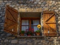 Window in the foreground of an old rural stone house in the Pyrenees with open wooden windows and precious pots. Royalty Free Stock Photo