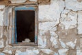 Window without glass with broken frame on peeling wall of old ruined house Royalty Free Stock Photo