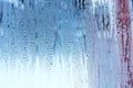 Window glass with condensation, high humidity in the room, large water droplets, cold tone