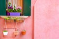 Window with green shutters and flowers on the pink wall Royalty Free Stock Photo