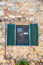 A window with green shutters on a Tuscany stone wall in the Chianti region of Tuscany, Italy Royalty Free Stock Photo