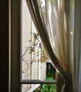 A window half covered with a curtain.