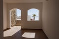 Window hole in the white stone wall of a building overlooking the Red Sea and a palm tree on a tropical beach in resort town Sharm Royalty Free Stock Photo