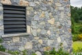 Window of a house closed with black wooden shutters. Old, ancient wood window with blind or shutters. Stone home facade Royalty Free Stock Photo