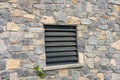 Window of a house closed with black wooden shutters. Old, ancient wood window with blind or shutters. Stone home facade Royalty Free Stock Photo