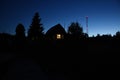 The window of the house glowing in the evening twilight