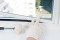 Window installation worker inserts glass into the frame and fastens it with a rubber mallet, rear view, close-up Royalty Free Stock Photo