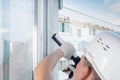 A window installation worker seals a plastic window frame with a sealant