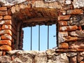 Window with iron bars in a rough wall made of natural stone Royalty Free Stock Photo