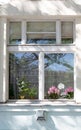 Window with vintage lace curtains and pretty summer flowers Royalty Free Stock Photo