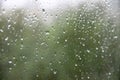 Window with large drops of rain on a green, gray, urban background. The first summer storm. Rain drops on a window Royalty Free Stock Photo