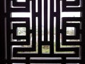 Window lattice, wooden or metal, black colored. Sunlit view out