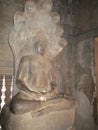 A window-lit corridor with several damaged buddha statues inside Angkor Wat, Cambodia.