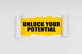 A window is made in the paper, where on a yellow background the inscription - Unlock Your Potential Royalty Free Stock Photo