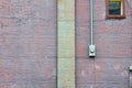 Window, meter box, and column against a purple painted brick wall Royalty Free Stock Photo