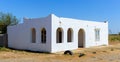 Window and old arched doorway in white building with white plastered textured weathered wall Royalty Free Stock Photo