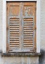 Window of old building covered by wooden blinds with peeling paint Royalty Free Stock Photo