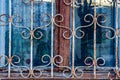 The window of an old house behind a metal patterned lattice Royalty Free Stock Photo