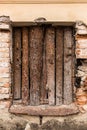 A window of an old house boarded up.