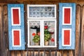 A colorful window of an old wooden cottage. Royalty Free Stock Photo