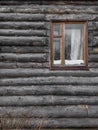 The window of the old wooden log house on the background of wooden walls Royalty Free Stock Photo