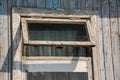 The window of the old wooden log house on the background of wooden walls Royalty Free Stock Photo