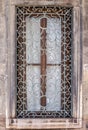Window with ornamented metal lattice on a stone building