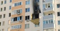 Window outside is black from the soot of the fire. An apartment building, the consequences of a fire, a burnt wall