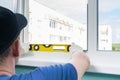 The window replacement wizard checks the window sill installation level with a yellow instrument Royalty Free Stock Photo
