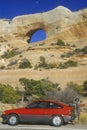 Window Rock Arch in southern UT with red car in foreground Royalty Free Stock Photo