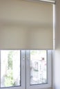 Window roller blind is pulled down, blocking the view of the city outside Royalty Free Stock Photo