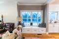 Window seat in between white kitchen with textured subway tile and a living room