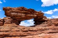 Window-shaped archway cut into a sandstone rock formation in Kalbarri National Park, Australia.