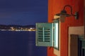 Window of a shuttered house at night with sea bay Royalty Free Stock Photo