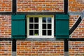 Window with shutters in brick wall of half timbered house Royalty Free Stock Photo