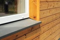 Window Sill with Modern Wooden Facade Wall. Single plastic window sill detail.