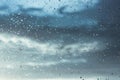 Window, raindrops on surface against blue cloudy sky after storm. Rainy weather. Royalty Free Stock Photo