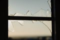 Window with some lefts of broken glass and the light is fading out. Royalty Free Stock Photo