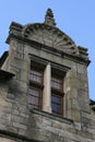 The window of a stone house situated in Rocherfort-en-terre, France, is surmounted by a sculptured curved pediment