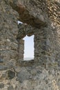 Window in the stone wall overlooking blue sky of the ghost town Kayakoy. Mugla - Turkey