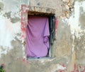 The window of a very old collapsed abandoned house hung with a pink rag, Royalty Free Stock Photo