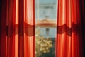 A window with a vibrant red curtain, suitable for interior design projects Royalty Free Stock Photo
