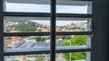 Window view through the blinds. City from inside of the house. Sea town in a hill view from the wooden shutters