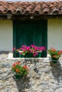 Window view of country house with planters with red geraniums and pink petunias, a sunny day, northern Spain Royalty Free Stock Photo